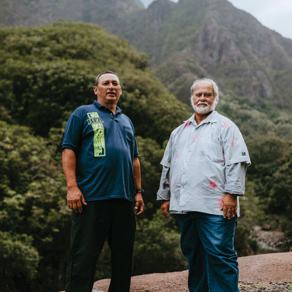 Bishop Pahia and Juanito Dudoit standing in front of a mountain ridge on Maui.