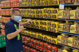 Staff stocking bread in grocery aisles