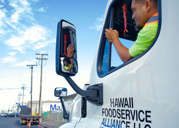 driver looking in rearview window inside company truck