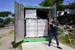 Coworker opening a freighter crate of goods.
